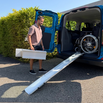 Zweifach Faltbare Schienenrampen für Rollstühle an einen Kofferraum gelehnt