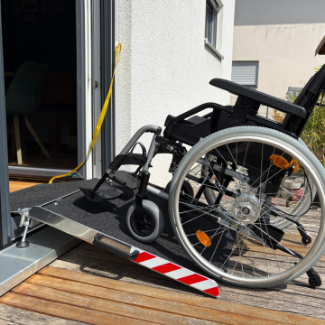 Rollstuhlrampe für Balkon & Terrasse mit einem Rollstuhl an einer Terrassentür