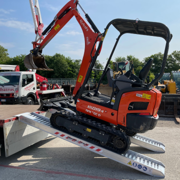 Alu Auffahrrampen für Bagger an einem Lastwagen aufgelegt