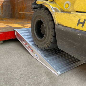 Container Auffahrrampen liegt an einem Container an und ein Hubwagen fährt die Rampen hinauf