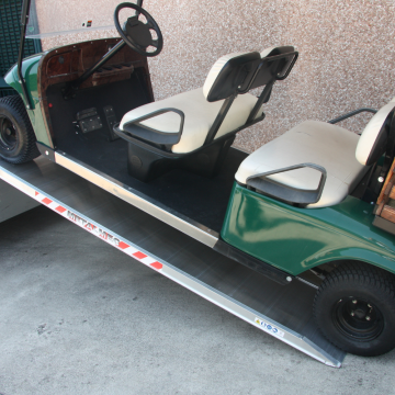Ein Golf Buggy wird auf einem Paar Eventschienen verladen