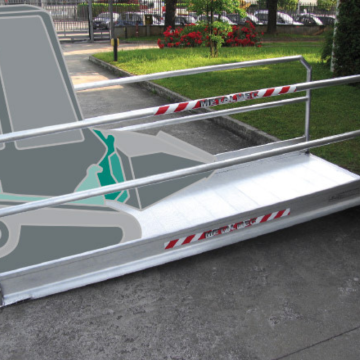 Fahrzeugbrücke mit Geländer wird von einem kleinen Bagger befahren