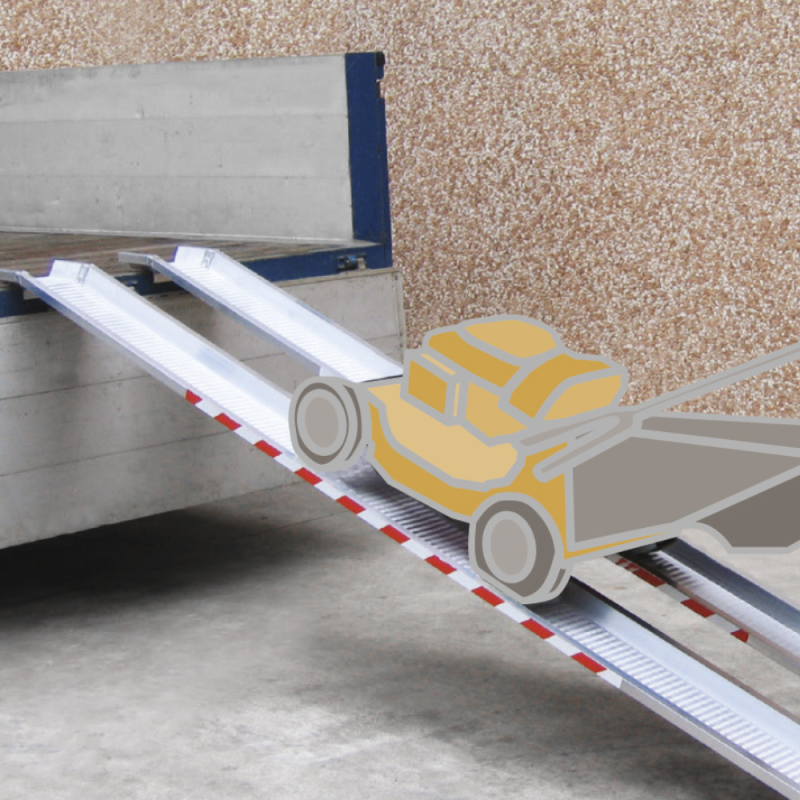 Ein Rasenmäher wird auf den Auffahrschienen auf einen Transporter verladen, in der Seitenansicht