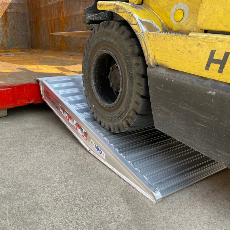 Container Auffahrrampen liegt an einem Container an und ein Hubwagen fährt die Rampen hinauf