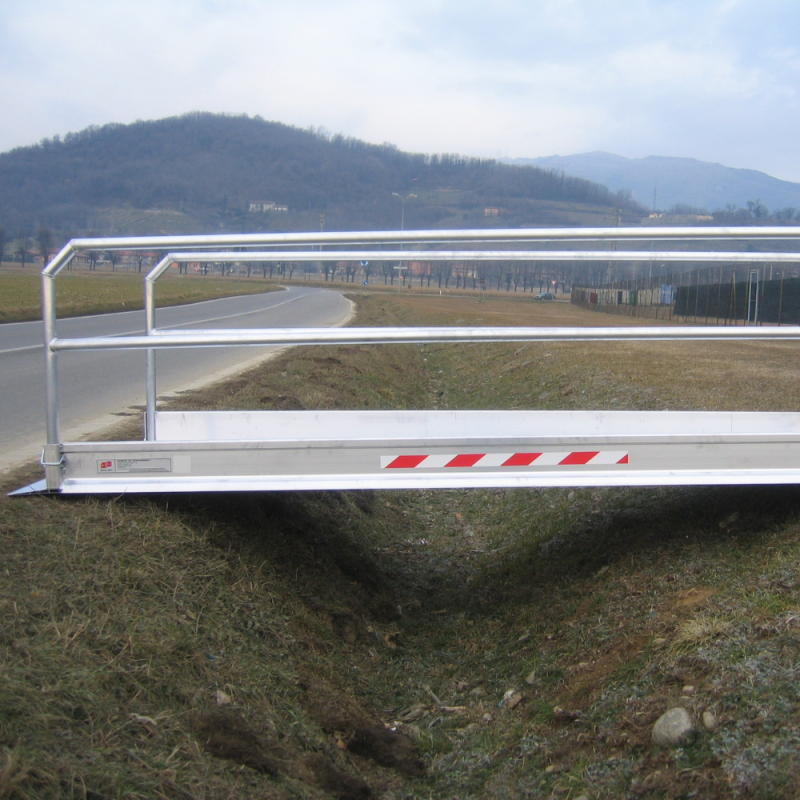 Fahrbrücke mit Geländer über eine Grube gelegt
