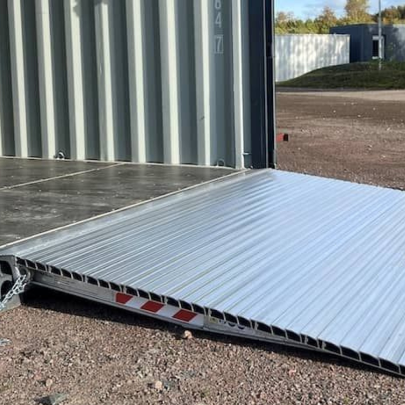 Die Container Rampe Alu mit 1 t & 2 t Tragkraft liegt an einem Container an